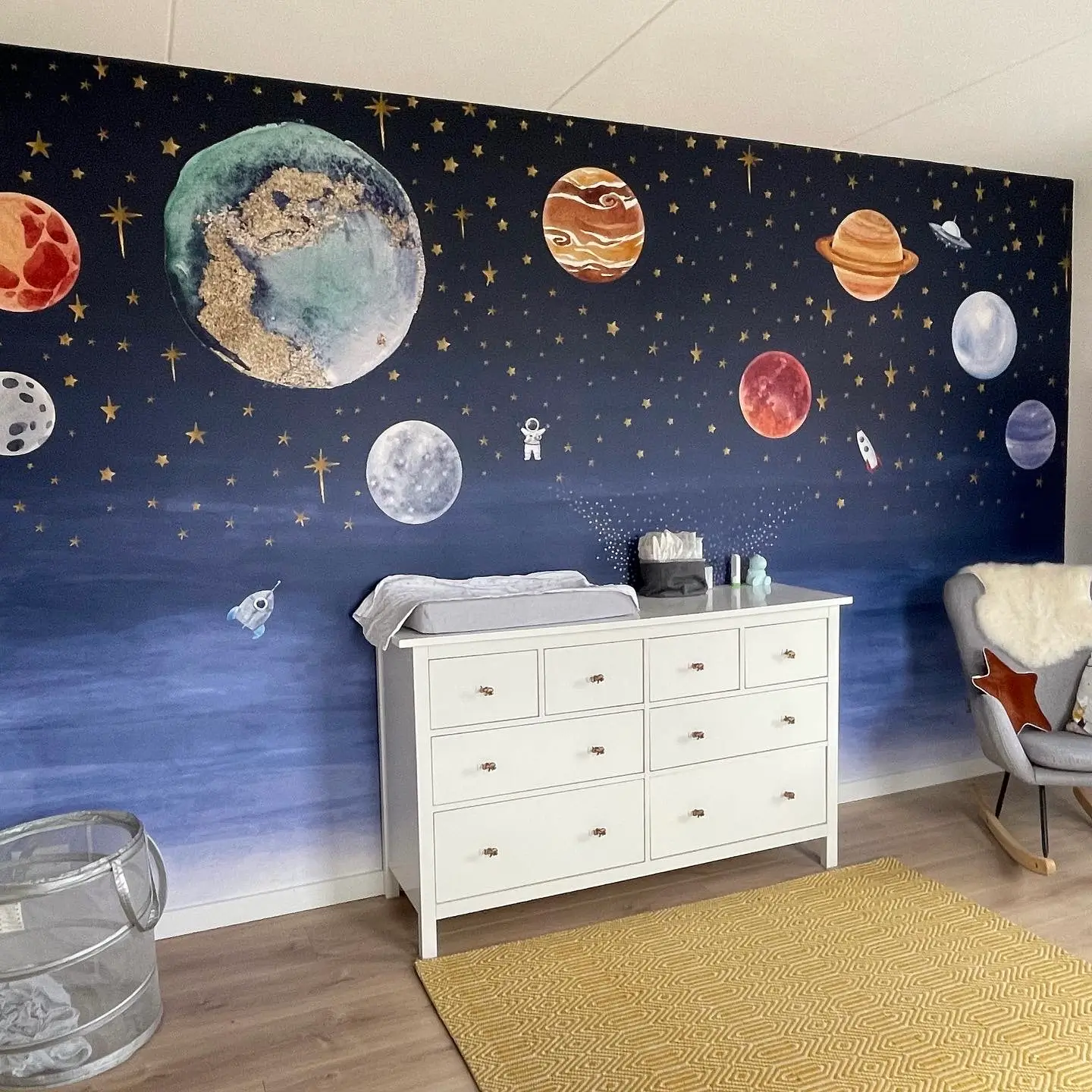 kinderkamer met muur met behang van planeten, het heelal.